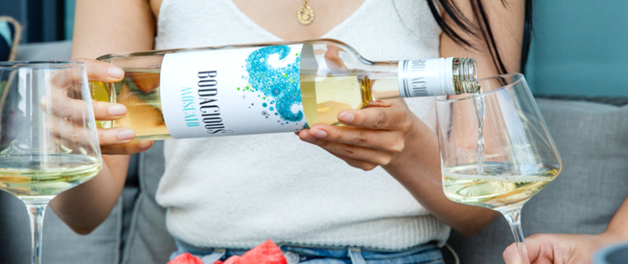 Lady is holding a bottle of White Bodacious wine